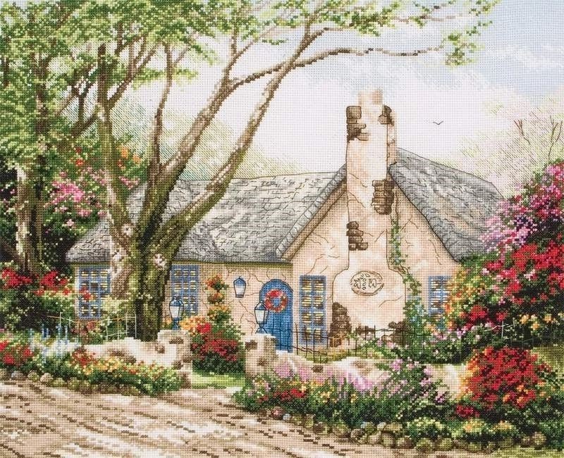 Красивый небольшой дом в деревне и кусты с цветами
